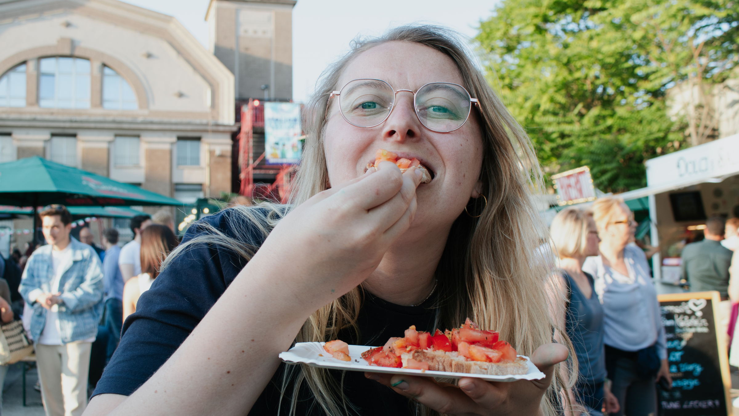 Visitor tasting bruschetta at an event, photographed for social media content